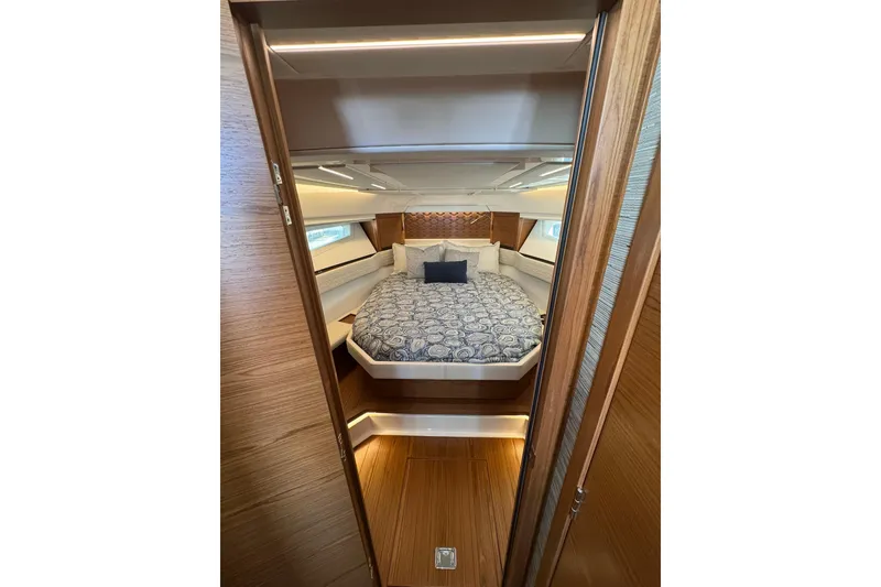 Slide: The Image of Luxurious cabin interior of 2025 Tiara Yachts 43 LE with elegant bedding and wood finishes. - 43