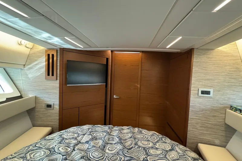 Slide: The Image of Luxurious interior of 2025 Tiara Yachts 43 LE with modern wood paneling and cozy bedding. - 46