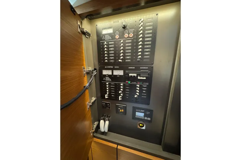 Slide: The Image of Electrical control panel inside 2025 Tiara Yachts 43 LE, showcasing switches and circuit breakers. - 47
