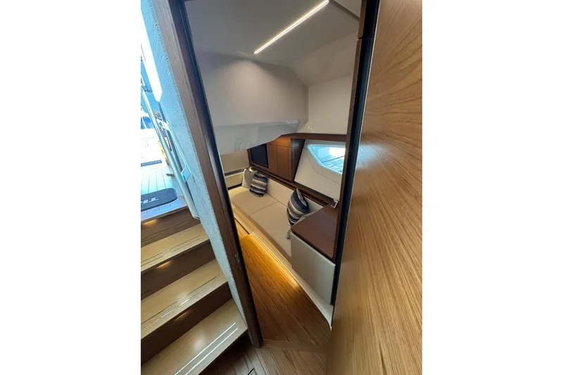 Slide: The Image of 2025 Tiara Yachts 43 LE interior cabin with modern wood finish and cozy seating. - 48