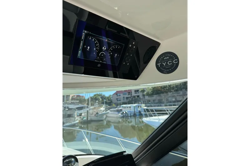 Slide: The Image of Dashboard of 2025 Tiara Yachts 43 LE with digital display and marina view. - 62