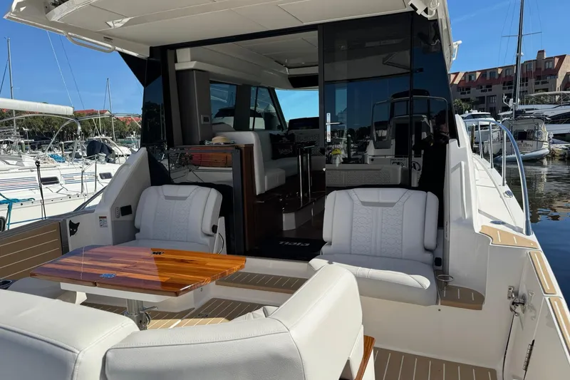 Slide: The Image of 2025 Tiara Yachts 43 LE luxury yacht interior with seating and table, docked at marina. - 69