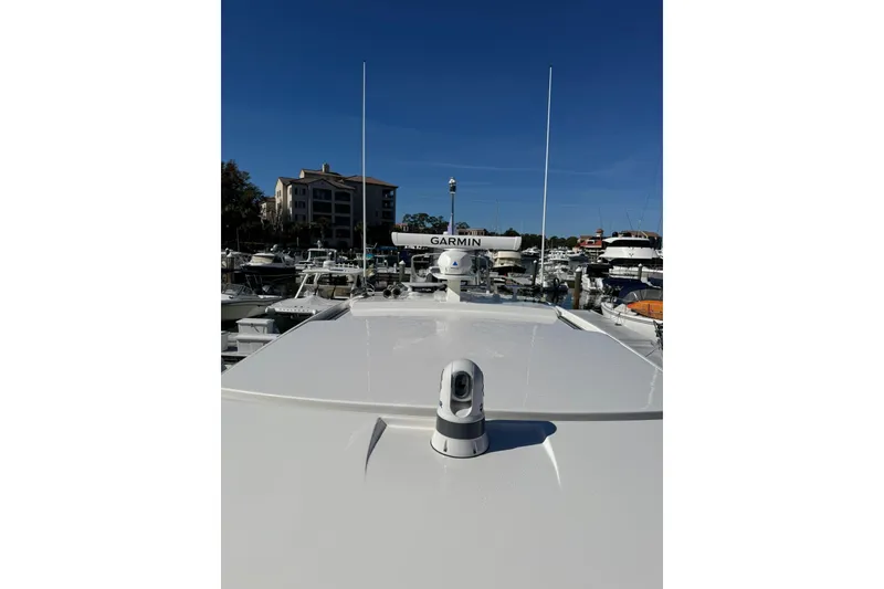 Slide: The Image of 2025 Tiara Yachts 43 LE with Garmin equipment, docked in a marina under clear blue skies. - 73