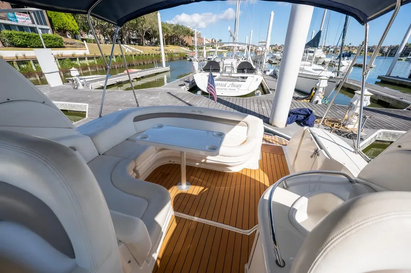 Slide: The Image of 2005 Sea Ray 340 Sundancer yacht interior with seating and table at marina. - 11