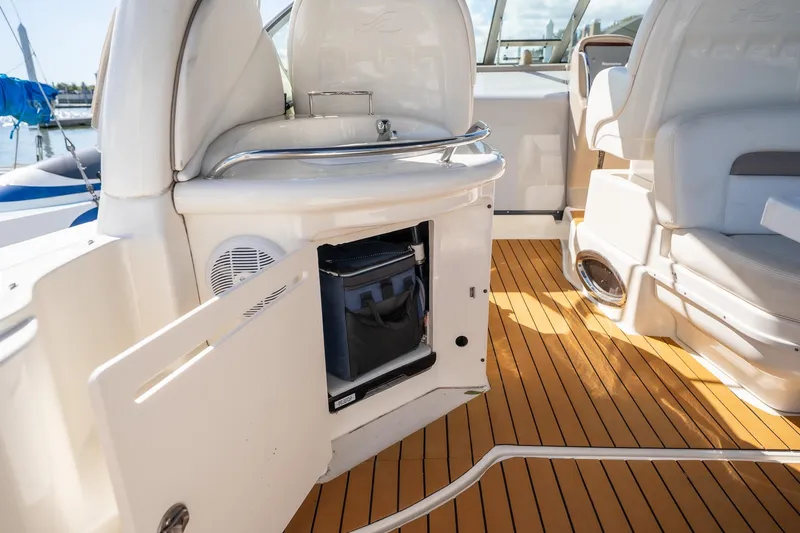 Slide: The Image of 2005 Sea Ray 340 Sundancer interior with open storage, white seating, and wood-style flooring. - 12