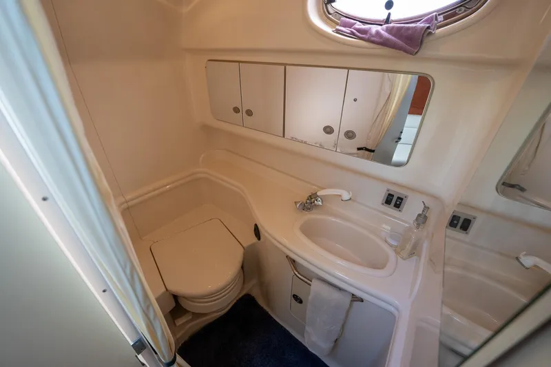 Slide: The Image of 2005 Sea Ray 340 Sundancer bathroom with sink, toilet, and storage cabinets. - 33