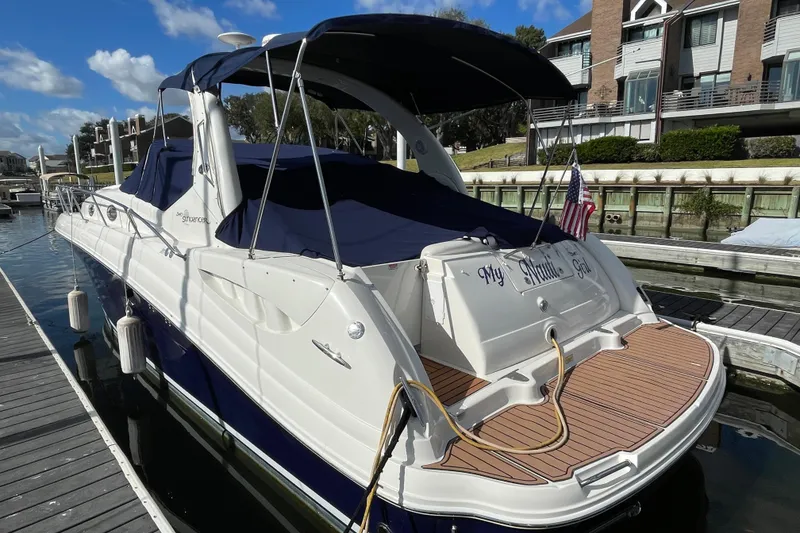 Slide: The Image of 2005 Sea Ray 340 Sundancer docked, featuring teak swim platform and American flag. - 9