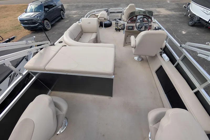 Slide: The Image of 2016 Avalon GS 22' pontoon boat interior with beige seating and steering console. - 10
