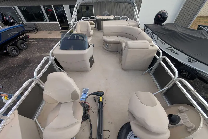 Slide: The Image of 2016 Avalon GS 22' pontoon boat interior with beige seating and steering console. - 4