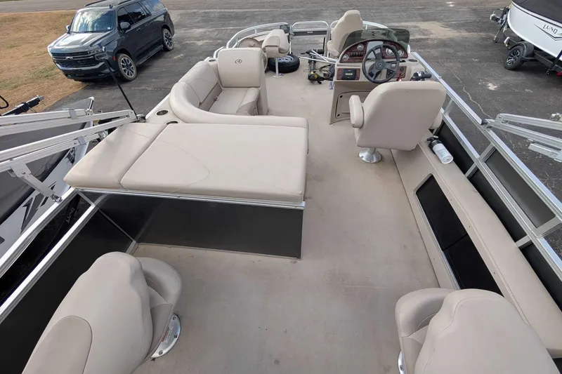 Slide: The Image of 2016 Avalon GS 22' pontoon boat interior with beige seating and steering console. - 6