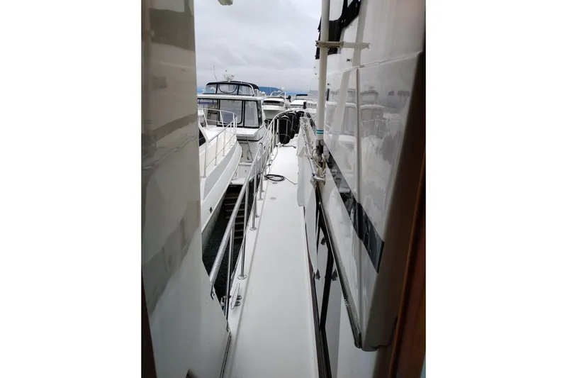 Slide: The Image of Side view of a 1991 Jefferson 48 Rivanna Sundeck yacht docked at a marina. - 11