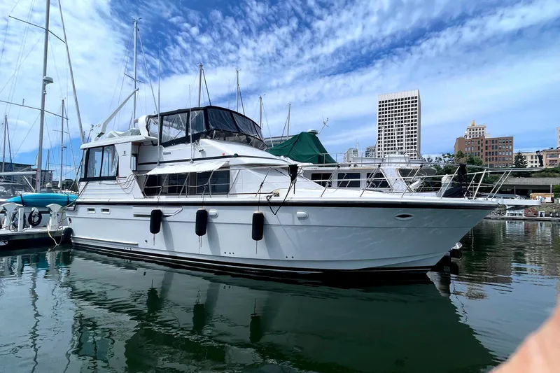 Slide: The Image of 1991 Jefferson 48 Rivanna Sundeck yacht docked, blue sky. - 2