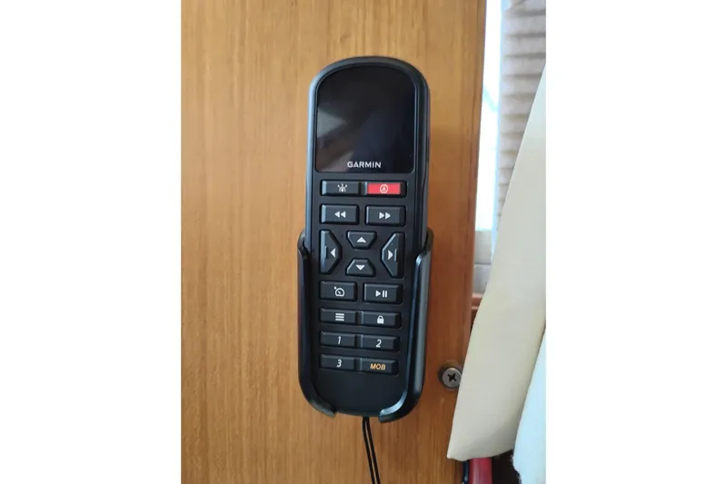 Slide: The Image of Garmin remote control mounted on a wooden panel inside a 1991 Jefferson 48 Rivanna Sundeck. - 36