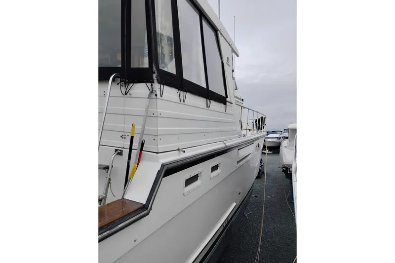 Slide: The Image of 1991 Jefferson 48 Rivanna Sundeck yacht docked, showcasing sleek design and spacious deck. - 4