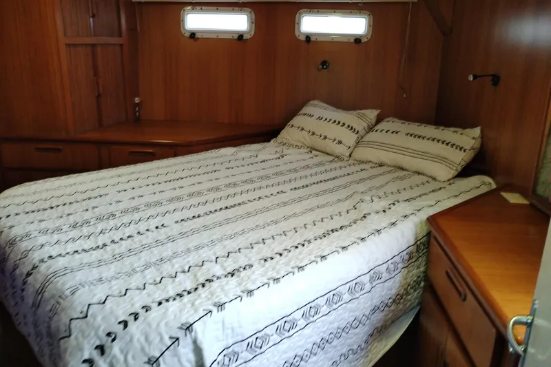 Slide: The Image of Cozy bedroom interior of 1991 Jefferson 48 Rivanna Sundeck yacht with wood paneling and patterned bedding. - 62