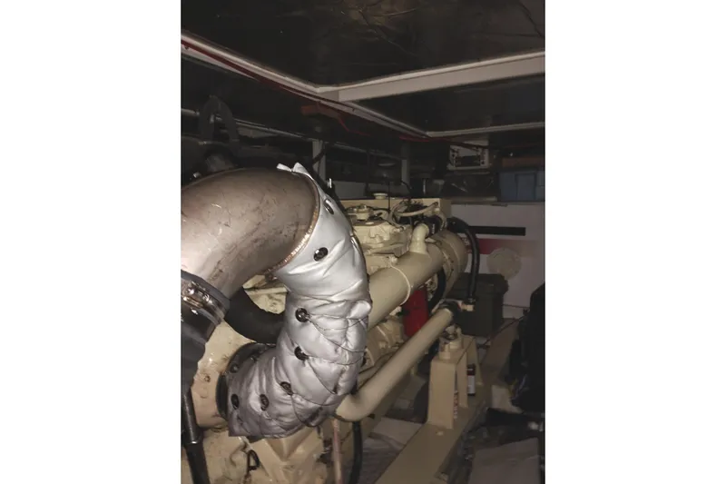 Slide: The Image of Engine room of a 1991 Jefferson 48 Rivanna Sundeck yacht, featuring insulated exhaust components. - 74