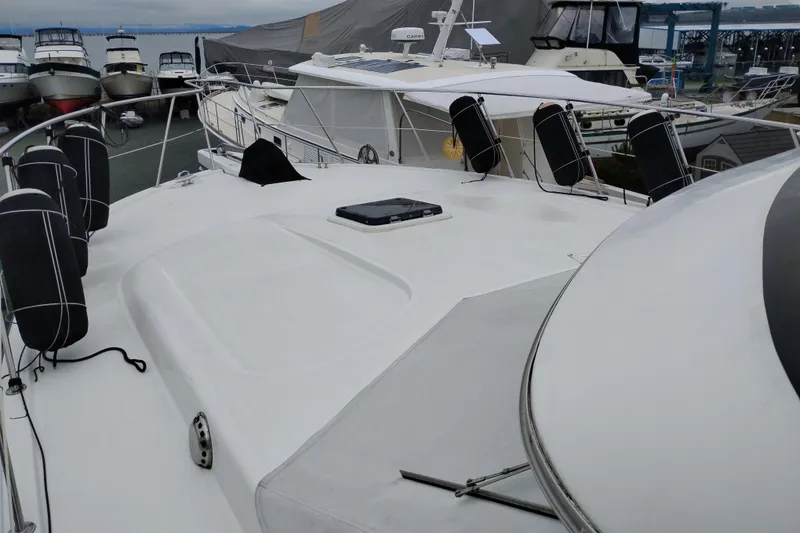 Slide: The Image of 1991 Jefferson 48 Rivanna Sundeck yacht docked at marina, showcasing spacious deck area. - 80