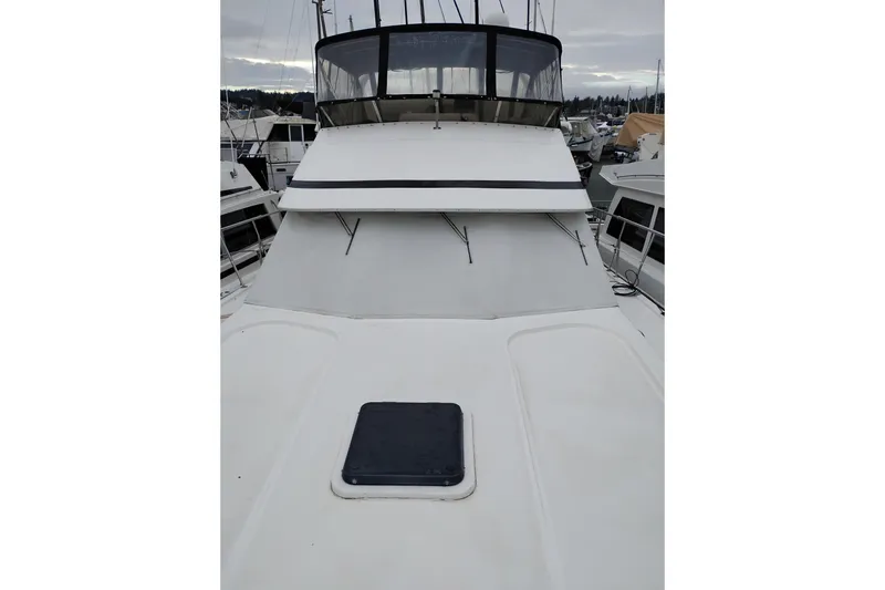 Slide: The Image of 1991 Jefferson 48 Rivanna Sundeck yacht, docked, with visible flybridge and deck hatch. - 83