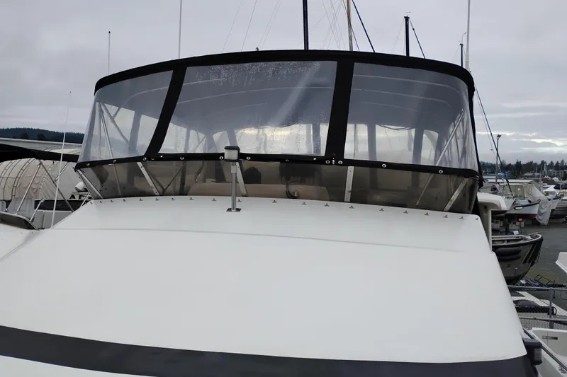 Slide: The Image of 1991 Jefferson 48 Rivanna Sundeck yacht with enclosed flybridge, docked at marina. - 85