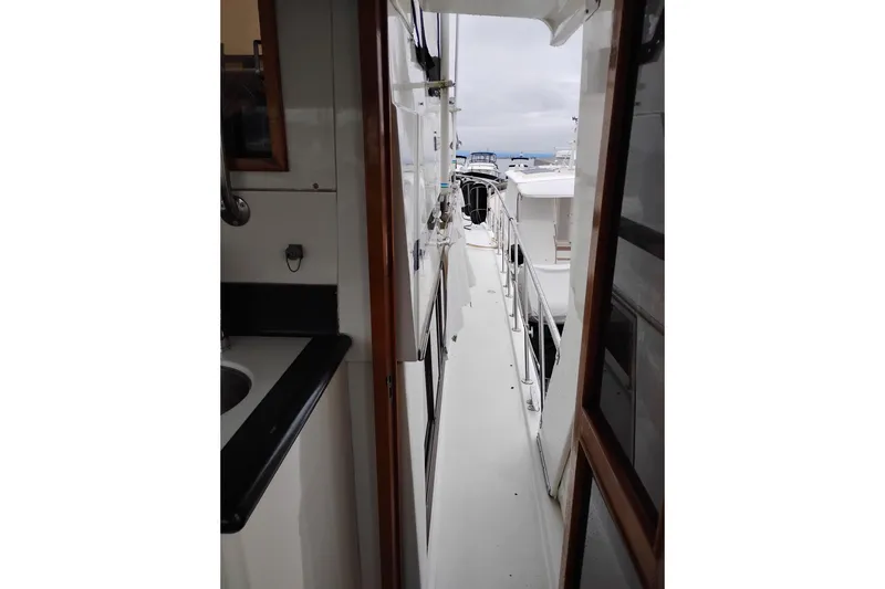 Slide: The Image of Narrow walkway on 1991 Jefferson 48 Rivanna Sundeck yacht, featuring sleek design and ocean view. - 9