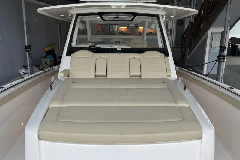 Slide: The Image of 2019 Pursuit S 408 Sport boat with beige seating in a marina setting. - 31