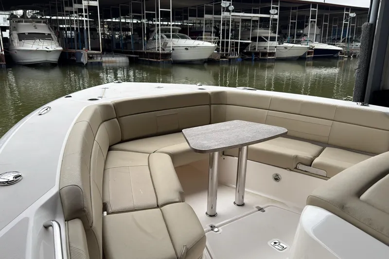Slide: The Image of 2019 Pursuit S 408 Sport boat with beige seating and table in marina. - 33
