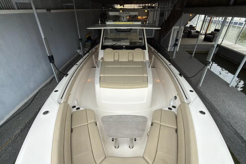 Slide: The Image of 2019 Pursuit S 408 Sport boat with beige seating and table in docked position. - 35