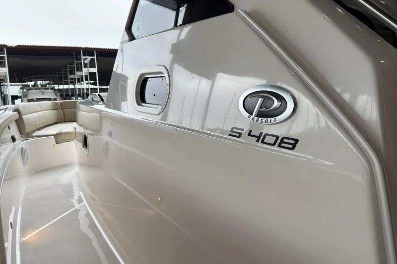 Slide: The Image of 2019 Pursuit S 408 Sport boat, sleek design with logo, docked in marina. - 38