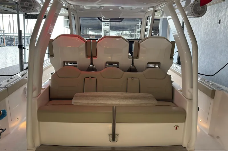 Slide: The Image of 2019 Pursuit S 408 Sport boat interior with seating and table, dockside view. - 49