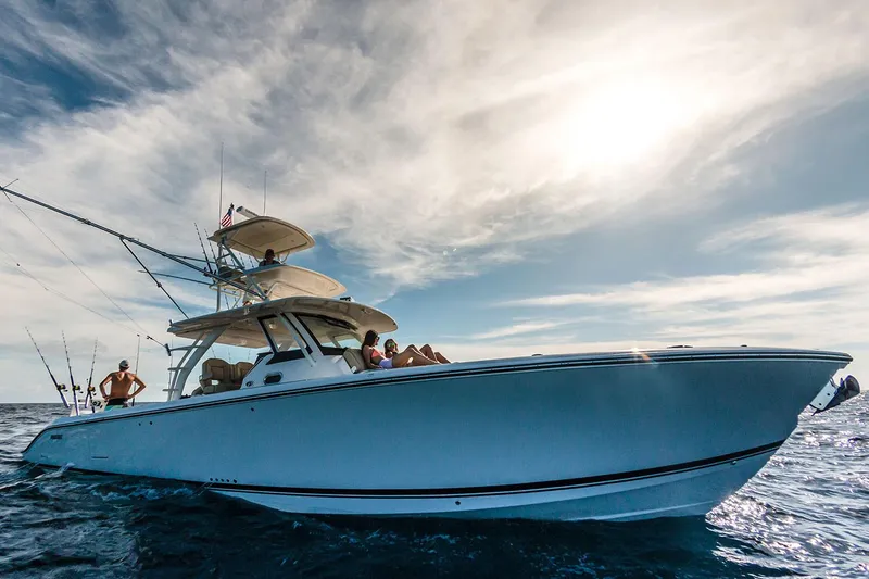 Slide: The Image of 2019 Pursuit S 408 Sport boat cruising on open water under a clear blue sky. - 5