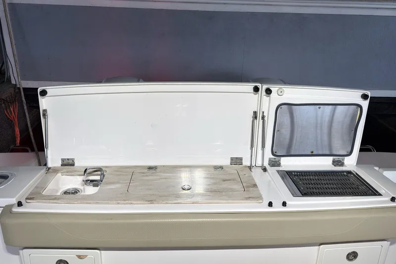 Slide: The Image of 2019 Pursuit S 408 Sport boat with open storage compartments and sink. - 50