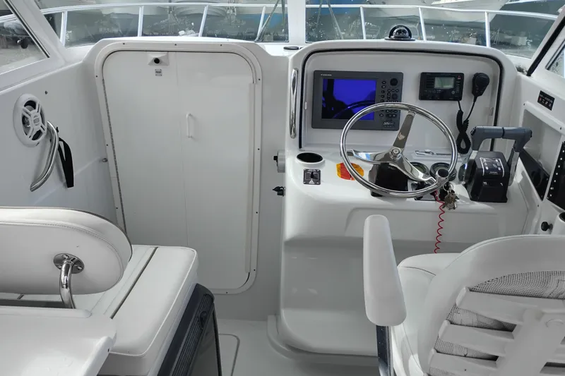 Slide: The Image of 2007 Glacier Bay 2685 Coastal Runner helm with steering wheel and navigation equipment. - 19