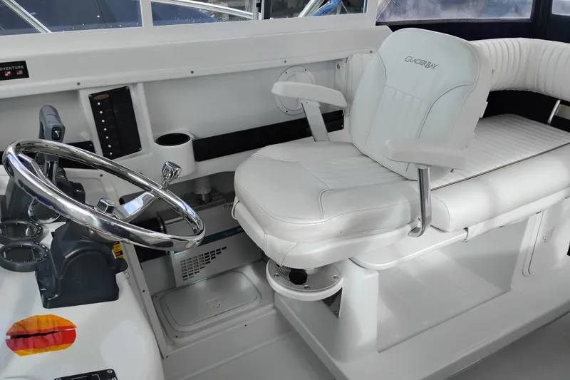 Slide: The Image of 2007 Glacier Bay 2685 Coastal Runner helm with white captain's chair and steering wheel. - 22