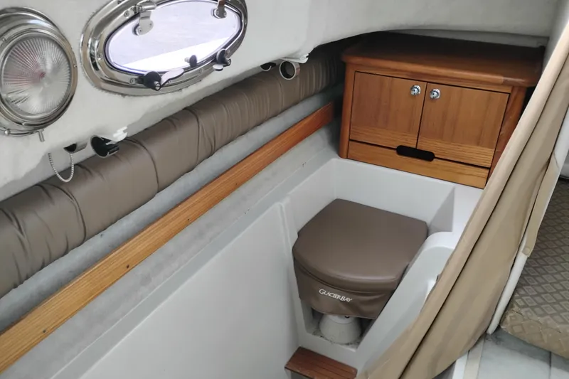 Slide: The Image of 2007 Glacier Bay 2685 Coastal Runner cabin with compact toilet and wooden storage cabinet. - 36