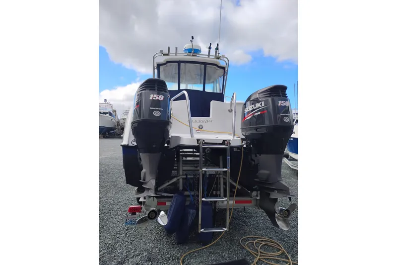 Slide: The Image of 2007 Glacier Bay 2685 Coastal Runner with dual Suzuki 150 engines, parked on gravel. - 4