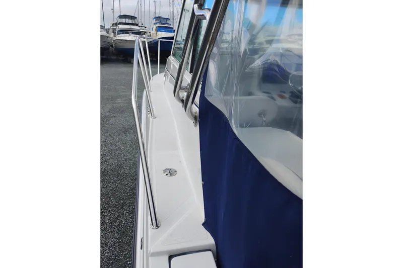 Slide: The Image of 2007 Glacier Bay 2685 Coastal Runner boat with blue canopy and stainless steel railings. - 9