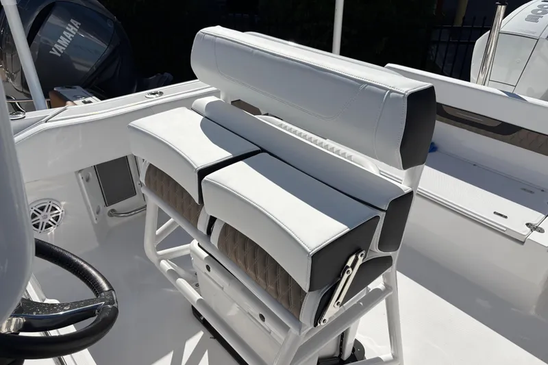 Slide: The Image of 2024 Blackfin 222CC boat interior with white cushioned seating and Yamaha engine. - 17