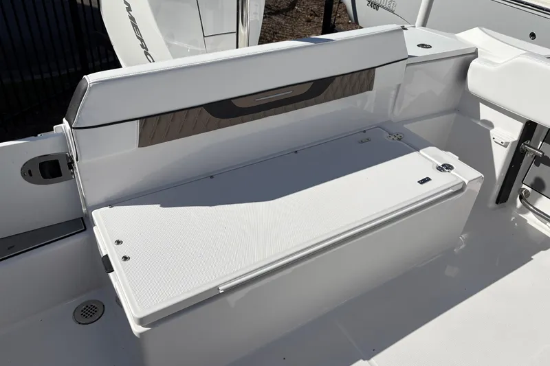 Slide: The Image of 2024 Blackfin 222CC boat seating area with storage compartment, featuring sleek white design. - 20