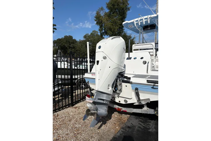 Slide: The Image of 2024 Blackfin 222CC boat with powerful outboard motor, parked outdoors on a sunny day. - 4