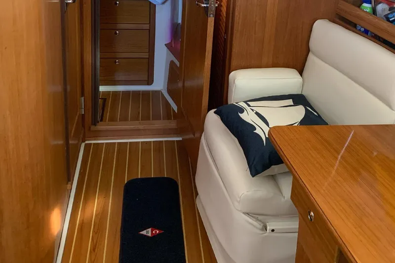 Slide: The Image of Interior of a 2003 Catalina 350 sailboat with wooden flooring and white seating. - 3