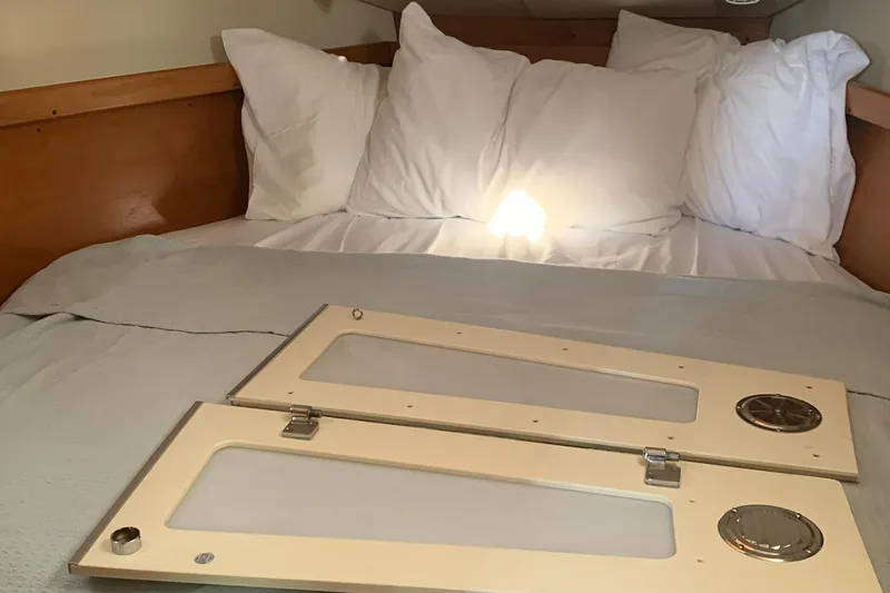 Slide: The Image of Cozy cabin bed in a 2003 Catalina 350 sailboat with white pillows and wooden accents. - 7
