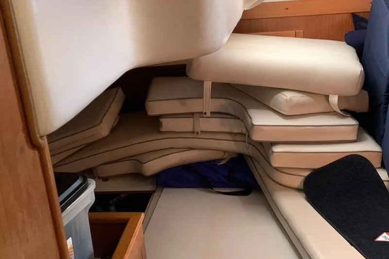 Slide: The Image of Interior of a 2003 Catalina 350 sailboat with stacked beige cushions. - 9