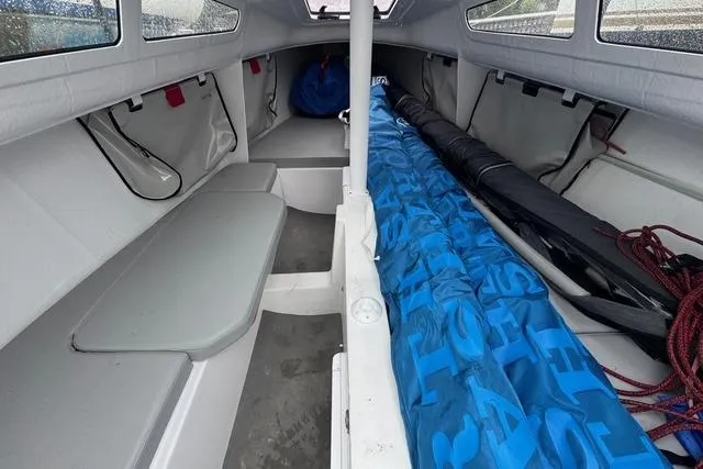 Slide: The Image of Interior of 2022 Beneteau First 24 SE sailboat, featuring compact seating and storage. Packed for travel - 26