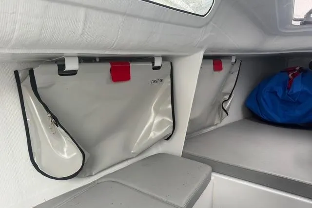 Slide: The Image of Interior of 2022 Beneteau First 24 SE sailboat with storage compartments and seating. - 29