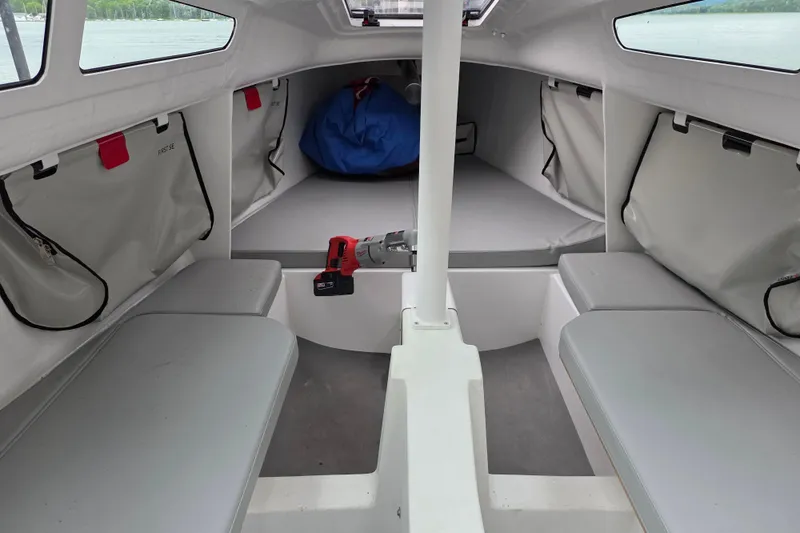 Slide: The Image of Interior of 2022 Beneteau First 24 SE sailboat, featuring seating and storage compartments. - 3