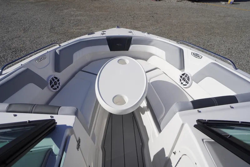 Slide: The Image of 2026 Chaparral 23 SSi OB boat interior with seating and table, showcasing modern design. - 11