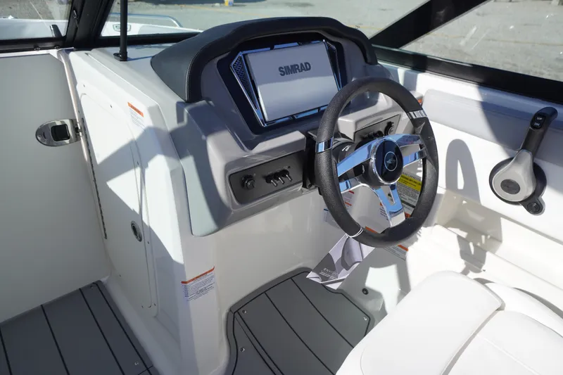 Slide: The Image of 2026 Chaparral 23 SSi OB boat cockpit with steering wheel and Simrad display. - 22