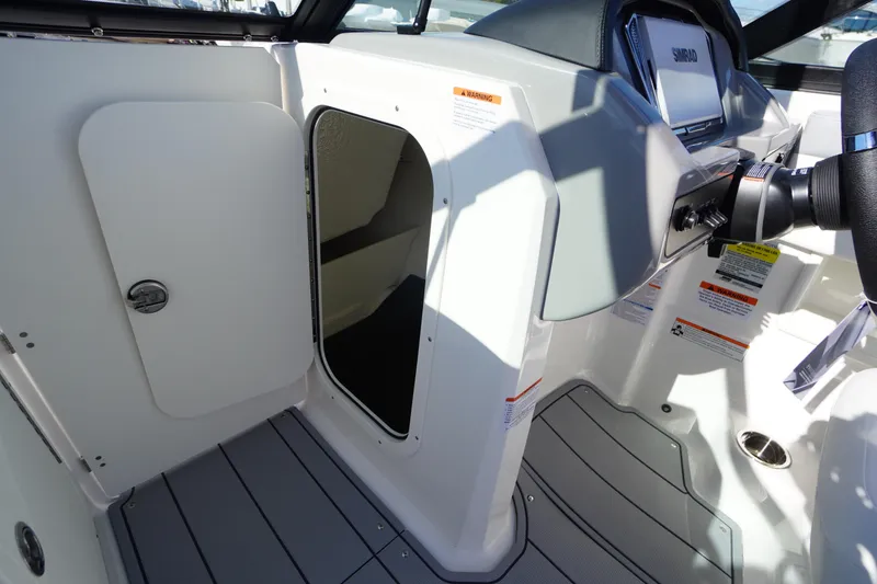 Slide: The Image of 2026 Chaparral 23 SSi OB boat interior with helm and storage compartment. - 30