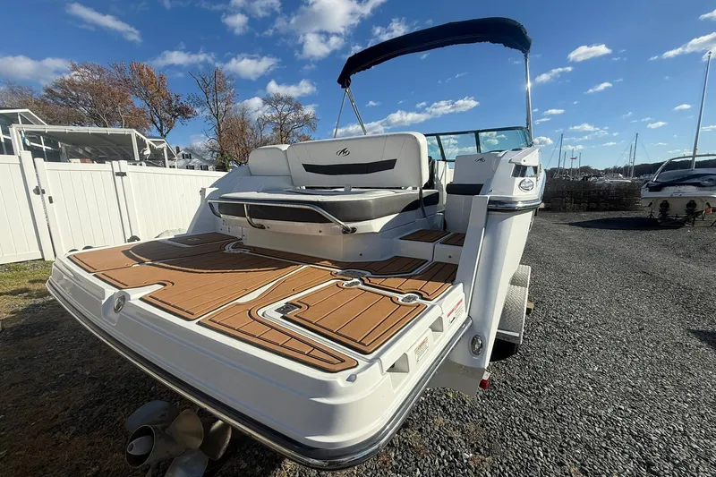Slide: The Image of 2016 Monterey 258SS Super Sport boat with teak deck, parked outdoors under blue sky. - 6