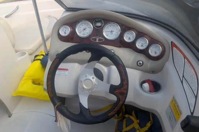 Slide: The Image of Steering wheel and dashboard of a 2011 Tahoe Q5L I/O boat with gauges and controls. - 2